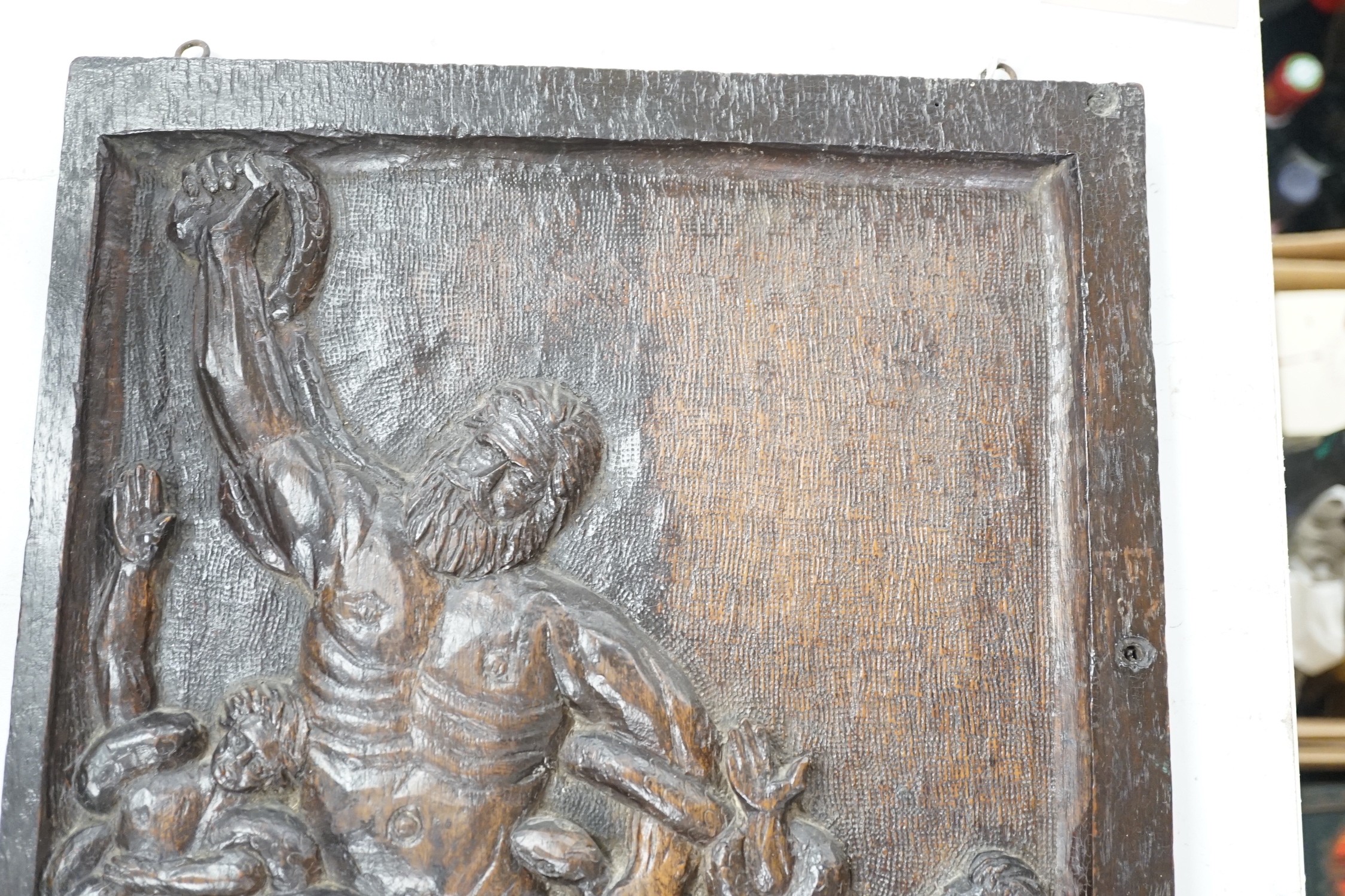 A carved oak figural panel depicting Laocoön and his son is fighting serpents, 46 x 32cm